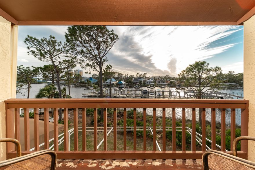 CURRENTLY UNDER CONTRACT, SELLER ACCEPTING BACKUP OFFERS. Yes! You could own a waterfront 2-bedroom, 2-bath property in Panama City Beach! This beautiful unit overlooks Grand Lagoon from two balconies and comes furnished and move-in ready! Enjoy indoor or outdoor entertaining in the open floor plan and large outdoor deck overlooking the lagoon. The master retreat features a stunning cathedral wood ceiling, private ensuite bath, incredible amounts of storage including full wall built-ins and beautiful water views from the private balcony. Point Lagoon is a beautifully landscaped and quiet resort-style community. Boat storage available and slips often come up for sale or rent if you're a boater, but there are spots to tie up for short-term docking! Low HOA even includes water, sewer, cable+