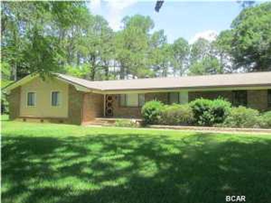 Price Reduced! Looking for land and a great location on Panama City Beach to call home? Sitting on 1+ acre of land and conveniently located to the Navy Base and Hathaway Bridge is this well-constructed and well-maintained, 3 bedrooms with 2 baths, brick home. There are no other homes on PCB for sale with a lot this size. And, all lots on Laird Circle are at least an acre in size. This lot has beautiful trees and there is plenty of room to add a pool. The yard is easy to care for with a low maintenance landscape theme and sprinkler system with separate well and automatic timer (2011). The living room features a brick, wood burning fireplace and solid wood built-in bookshelves. The home has been well-maintained: roof replaced in 2007 (30 year asphalt shingles; house exterior painted in 2009