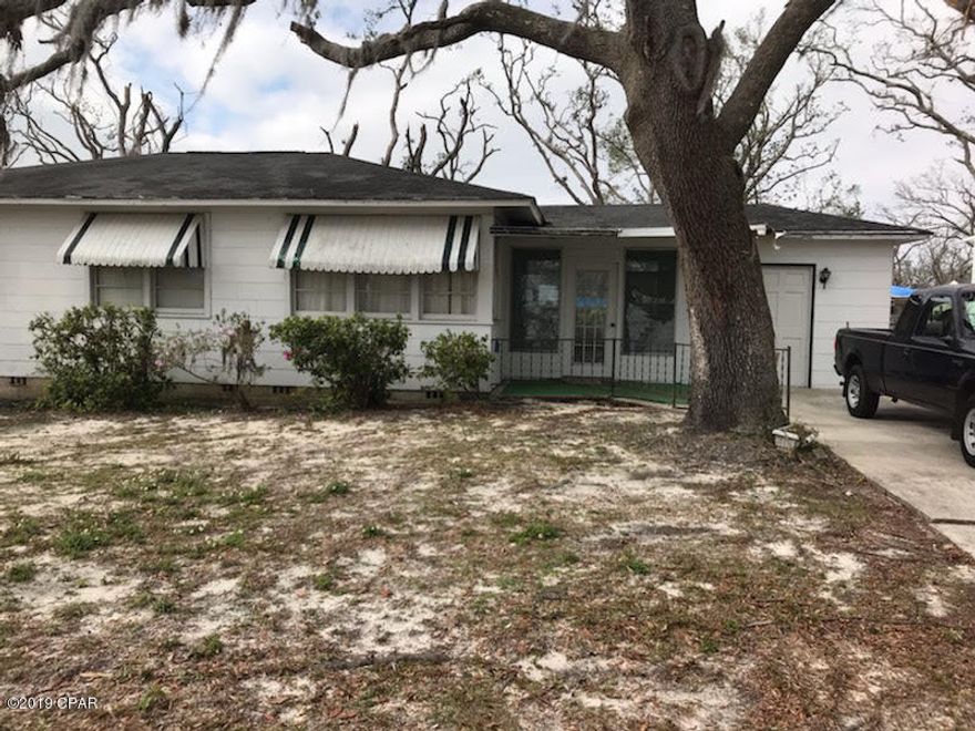 Nice Cove home  3/2.  The home is livable but with some TLC but It could be a great home  Breezeway between garage and house.  Original hardwood through most of the house.  Lot has alley access.  There was no storm damage, but due to age the home needs a roof.