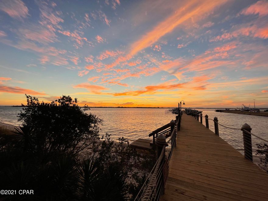 Beautiful, completely updated, 2 bed, 2 1/2 bath condo with sweeping views of St. Andrews Bay and breathtaking sunsets over the water, all year round. This stack offers a unique balcony bump out, providing 180 degree, unobstructed views of the bay as well as the enjoyment of the sea breeze entering from the front and both open sides of the patio. When built, this unit offered extra upgraded options, including a full outdoor kitchen, featuring a LYNX Stainless Steel natural gas grill, Fridgedaire SS refrigerator (new) and SS sink with H&C water. The oversize soaking tub in the Master bath is jetted for extra soothing relaxation. Since moving in in April, 2018,  the following updates have been made to this unit: KITCHEN... cabinets painted, glass backsplash added, kitchen faucet replaced, double SS sinks refurbished, under & over cabinet ambient lighting added, 2 hand blown pendant lights installed over the granite counter top. LIVING ROOM...4 speed, wall controlled ceiling fan, textured wallpapered accent wall, cordless "black-out" window shades, new 8' sliding glass doors, new bayfront windows. MBR & MASTER BATH.... new 8' sliding glass doors, new travertine stone walk-in shower with frameless glass door and sides. DINING ROOM .....Designer ceiling light w/wall dimmer switch. BALCONY.... Motorized, remote controlled Phantom Sun screen. LAUNDRY ROOM .....Matching Maytag Bravos W & D and custom storage cabinets added. ENTRY...... new 8' entry door w/ lockset and pendant light. UTILITY ROOM .....custom shelving, new A/C system installed (Air Handler and Compressor). The main living area (lr, dr, kit, entry and 1/2 bath) was freshly painted in November 2020. Flooring on the main living space is engineered bronze birchwood, the guest bath and laundry room is tile and the master bath is travertine stone. All window treatments and teak balcony furniture pieces are included.
Harbour Village Condominiums is a gated community. Since hurricane Michael,  the roofs on both buildings have been replaced, the pool has been refurbished, the exteriors and common area interiors have been entirely repainted. Other improvements include refurbished elevator cabs, replaced waterside boardwalk, rebuilt marina, replaced flooring, cabinets, etc. in the clubhouse, and in the process of finishing the recoating of exterior walkways and building signage. It offers a fully covered garage for it's residents along with a magnificent multi acre yard and flower gardened common area, surrounded by trees, shrubs and anchored by a community Gazebo w/ gas fireplace as well as gas and charcoal grills. It is located just west of the Oaks by the Bay Park with it's owns private gated entrance into the park from it's courtyard. Marina boat slips are available for purchase. When you purchase a slip, storage space is included.