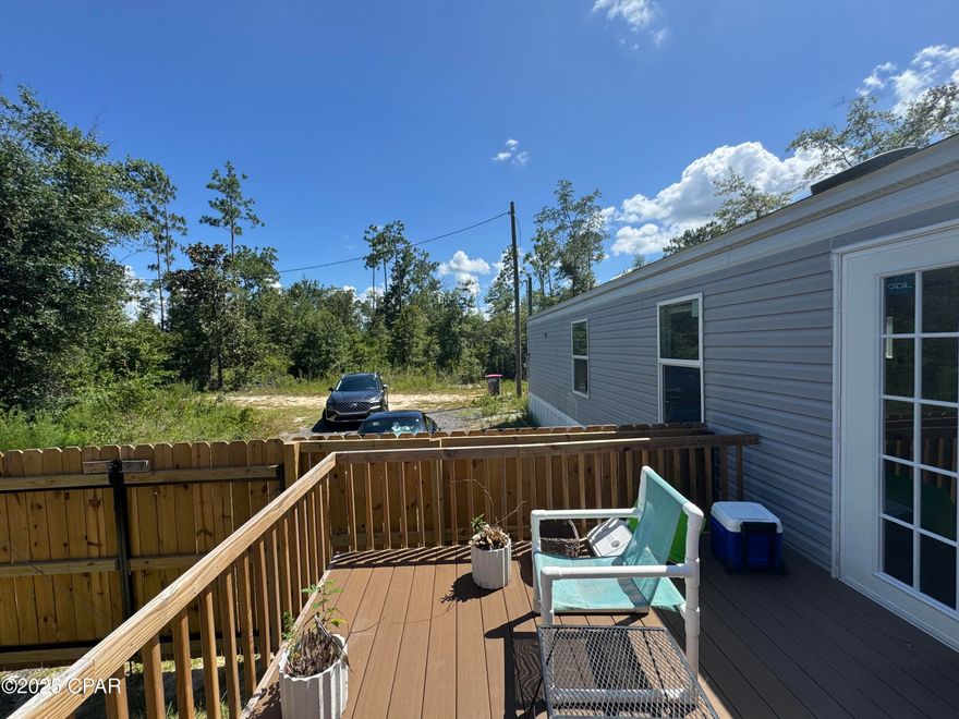 Start your mornings in this 2021-built home on the newly added deck, sipping coffee while surrounded by forest—no neighbors in sight, just peace, trees, and bird songs. When it rains, unwind on the covered porch; when the skies clear, enjoy evenings on the cement patio near a burn pit. Let your pets run free outside in the fully fenced  backyard that is gated for your security.

As you'll see when you step inside, this home is move-in ready with an all new freshly painted interior. French double doors add light and a beautiful view from the kitchen. Designed with privacy in mind, the home features a thoughtful split layout: with the primary bedroom (featuring an en suite bathroom and walk in closet) on one side, while two additional bedrooms and a full bath are located on the other — perfect for children, guests, or a home office. Rounding out this home are all the amenities you'll need: an EcoBee smart thermostat, new refrigerator with a chilled water dispenser, dishwasher, washer, and dryer.

Outdoor enthusiasts can take advantage of the many nearby activities the area has to offer. Kayak in the emerald, green waters of Pitt Springs and Ecofina Creek, enjoy the fishing and clear uncrowded beach at Compass Lake, or hike on the Scott Road trailhead portion of the Florida trail.

This home is located in flood zone X—no flood insurance required. The well water means no water bill, and with a new water purifying system, you'll have pure healthy water. This home blends the simplicity of rural living with the convenience of modern updates—perfect for first-time buyers, downsizers, or anyone seeking an affordable quiet retreat with room to breathe.