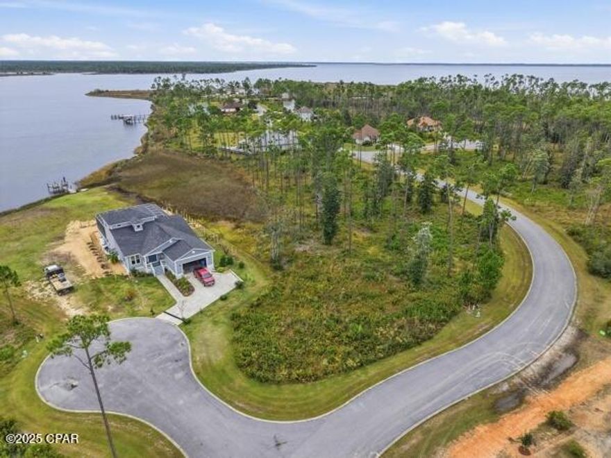 Enjoy the most prestigious, private  neighborhood of Laird Point as you envision yourself building your dream home overlooking Laird Bayou on this .386 vacant piece of residential land.  With 94 feet of frontage on the water you can enjoy the beautiful landscape of having your own residence meshed within luxury housing in this gated community.  Lot 54 is a waterfront paradise set right in a peninsula in an alcove overlooking the Bayou. The landscape and view is gorgeous.  Laird Point currently offers city utilities that are underground, curbed streets, pickleball courts, tennis courts, half court basketball, boat and RV storage, and a Marina with a community clubhouse.  
With low yearly HOA fees, one can see how well maintained this neighborhood is.  The HOA is currently in the process of putting a beautiful park in right across the street from this site.  Located not far from schools, shopping, and Tyndall AFB but set within the decor of a private secluded paradise.  The perfect location for anyone wanting luxury, the vibe of seclusion and beauty, privacy, but close to all that is needed.  Go see this lot and neighborhood and you will fall in love with this location and the ambiance of all that it offers.