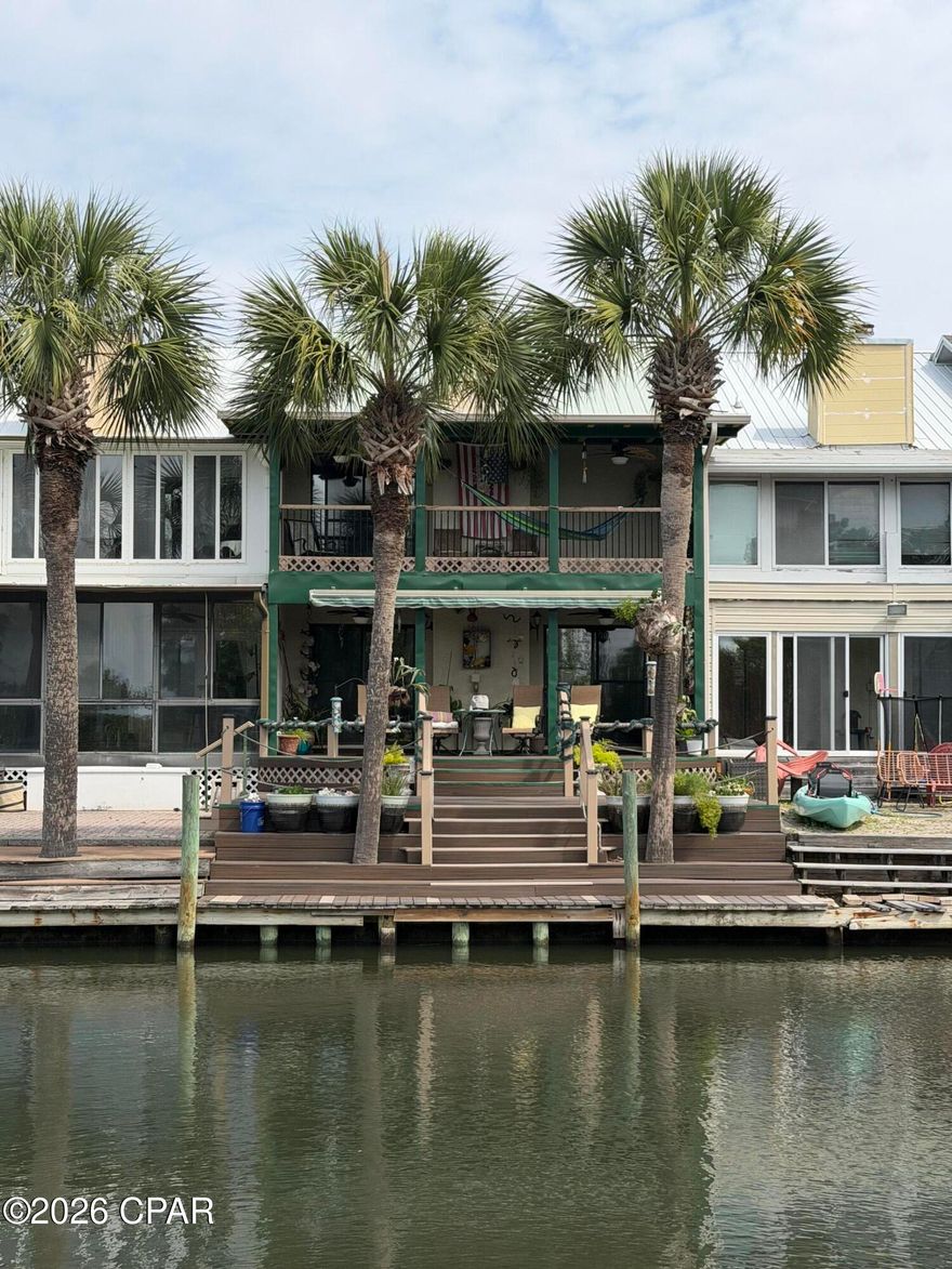 Prime Waterfront living with No HOA. Enjoy waking up in this townhouse with canal views and bay access at 1227 Capri Dr, Lynn Haven, FL. Bring your boat, kayak, or paddleboard and enjoy the peaceful coastal lifestyle with stunning sunset views. Located in Venetian Villa, this beautiful canal-front townhome offers unobstructed waterfront views and a well-designed open floor plan.

The first floor features ceramic tile, a spacious living and dining area, and an inviting kitchen equipped with a modern touchless faucet for added convenience. A stone fireplace creates a cozy atmosphere for cooler months. Step outside to the downstairs deck, perfect for relaxing or enjoying direct canal access for a small boat or jet ski. The decks were redone in 2022 with Trex Enhance decking for low maintenance and include an electric Sunsetter awning, creating a comfortable shaded outdoor space.

Upstairs you'll find 3 bedrooms and 2 baths, all carpeted, with large closets and plenty of storage space. The primary bedroom features a private balcony with ceiling fans, and a hammock that conveys with the home, making it a fun and relaxing spot to unwind and enjoy the sunshine and water views. After a fun day on the water, relax in the double jacuzzi tub.

The first floor also includes a half bath, laundry area, and access to the attached one-car garage. Centrally located in Bay County, this well-kept waterfront property offers the perfect blend of comfort, convenience, and coastal charm.