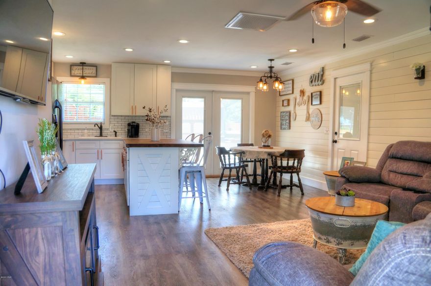 This pristine Florida cottage has been meticulously renovated. Plenty of recessed lighting lends to the open, airy feeling that is evident the moment you walk in the beautiful front door.  The large living, dining, kitchen combo room has gorgeous vinyl planked flooring, crown molding, and a tongue and groove accent wall. A custom-built kitchen island covered with a gorgeous butcher block countertop gives lots of extra work space.  Shaker cabinetry is accented with copper handles that complement the sparkly quartz countertops. In the guest bath, subway tiles surround the tub with a nook that matches the stylish floor tiles.  The Master bath has a stunning walk in shower with a rain shower head, and a flat river stone floor. A large privacy fenced backyard comes complete with a wood- fort fort swing set, and a workshop/yard building for convenience and added storage.  The solid brick exterior combined with a metal roof and gutters is a perfect set up for years of low maintenance living. A public boat ramp is located right up the street.