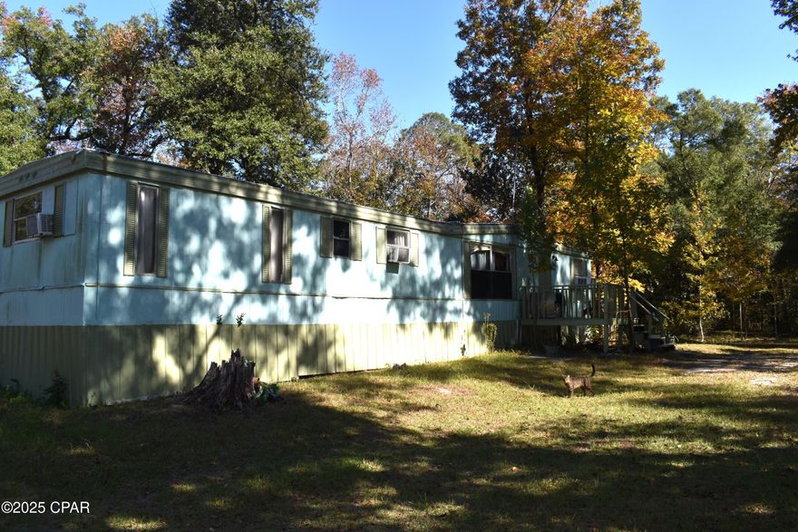 This 5-acre lot features a 2-bedroom, 1-bathroom single-wide mobile home situated in a rural area, ideal for a retreat, investment opportunity, or rental property. While the mobile home requires some repairs, it is still habitable but does not contribute to the overall value of the land. The property is equipped with essential improvements, including well water, septic system, and electrical utilities. Access is convenient via a paved road, and it is just a short drive from Panama City, Florida, as well as nearby lakes and rivers.
