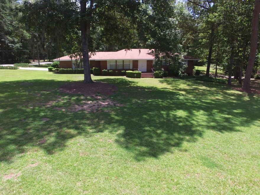 Lovely 3 bedroom, 2 bath home on a large 2+/- acre lot just North of downtown Marianna.  This well maintained home has hardwood flooring throughout most of the home, a new roof, & new a/c.  It is move in ready! You will love the master bath remodel the owner completed w/ step in shower, and the huge patio overlooking the private backyard. 4 sets of french doors provide panoramic views of this corner lot, and walk out to the back of the home. This home also has a large office, which could be used as a family room, game room, or even a 4th bedroom as it has it's own closet space. Home also has a termite bond in place, and a security system.