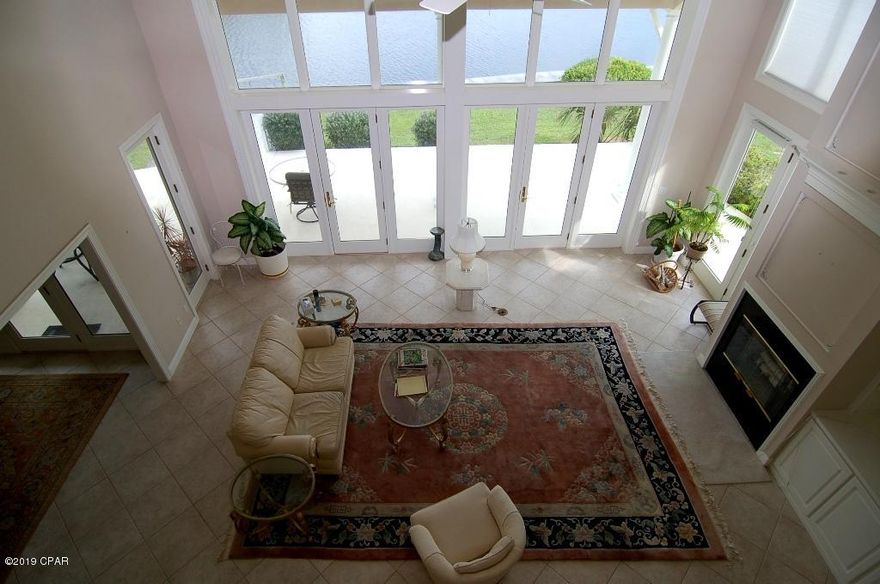 This expansive family room with soaring 20' ceilings has been creating cherished family memories for the last decade.  From piling on the couch with pillows and blankets on a cold winter day to enjoying a movie night by the fireplace to hosting a lively birthday gathering filled with friends and family.  This room is the heart of the home.  Those ceiling to floor windows in the family room provide gorgeous views of over 150' of all the activities on the bay.  All four bedrooms have bay views as well.  Make plans to see this home today. Click on more to see further details on this home. This home has 4 bedrooms 4 baths plus office with full bath, and elevator. This 2 story home has a balcony/patio for every bedroom. Master ensuite, office, family room, kitchen, and laundry are on the ground floor. Three bedrooms and two bathrooms upstairs. 4th bedroom closet/craft room. Upstairs storage area. Double garage and golf cart garage parking. All sizes are approximate. Buyer to verify any details buyer deems important. Bay Point annual dues $1325 and Bay Point Canal Owners annual dues are $250.0