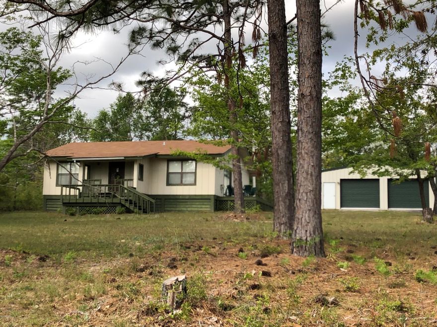 Tired of city living, well here's the place in a Country Bungalow with  2/2 with high ceilings giving that large  feel.  Big great room, all appliances stay, large 30x30 steel frame metal bldg on a concrete slab. Paved road frontage in the Compass Lake in the Hills Sub.  Comes with amenities ,pool, picnic areas with pavilion, boat ramp, fishing, swimming,  rental cabins if guest or family need a place to stay etc.