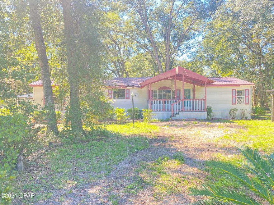 Large manufactured home on generous size lot. This home has covered front and back porches which extenuates the serene canopy feel under the large shade trees. There is a detached carport and workshop. The living room is huge and is complimented by a large family room with fireplace. While this home is in a country setting it is only about 40 minutes to the beaches. This property is now zoned for a commercial use.