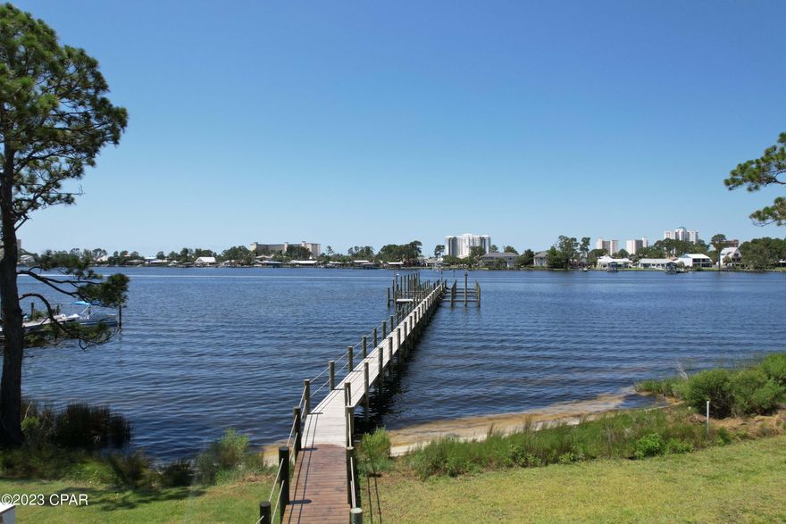 WATERFRONT.Bring your boat to the best Location on the beach.  New construction with a boat slip that will accommodate a 28 foot boat in a gated community. Just steps away from boat dock. Spend a day at Shell Island or the gulf fishing. This house has it all.  Downstairs master, hurricane windows and doors, gas stoves for cooking, tankless gas hot water heater, two-16 seer AC unit for energy efficiency. Wonderful neighbors and a community pool and low HOA dues.
House is scheduled to be completed in September, 2023.  Attached pictures are of completed homes that are sold and occupied. Buyer to verify measurements if important.