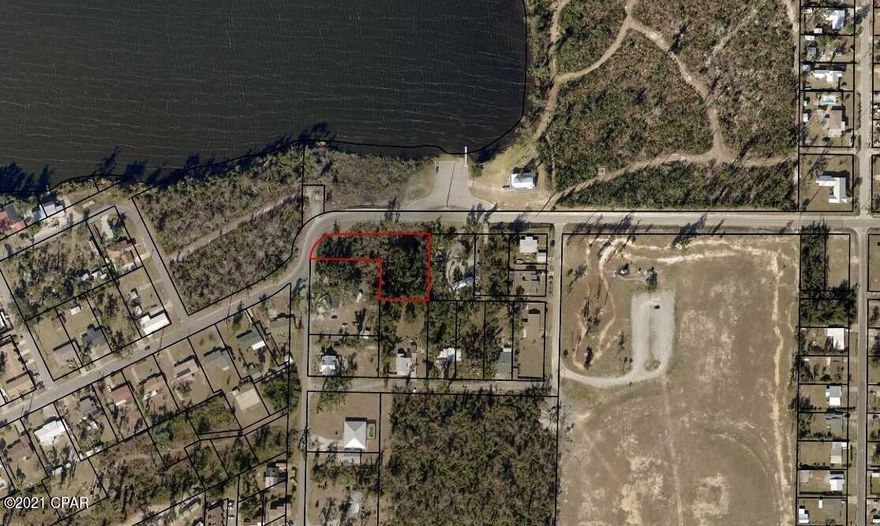 Over 1/2 acre wooded parcel with a pond and across the street from Martin Lake and a public boat ramp.  Seller says you could build your dream home or subdivide the lot and built 2 homes.  Great location, close to Tyndall AFB, shopping, schools and the bay!  All info is approx and must be verified by Buyers if important.