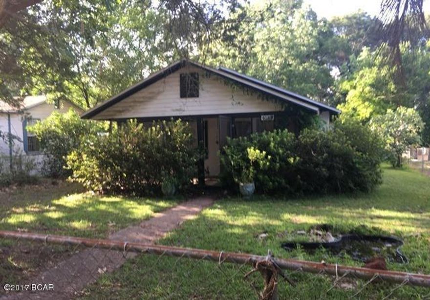 Very conveniently located near 23rd St and downtown, this home is made of sturdy concrete block. The ample sized yard is fenced and has outbuildings for storage, workshops and a carport. There is access to the alley behind the home. The front porch just needs a couple of rocking chairs! This 2 bedroom, 1 bath home would make a great starter home or investment property.