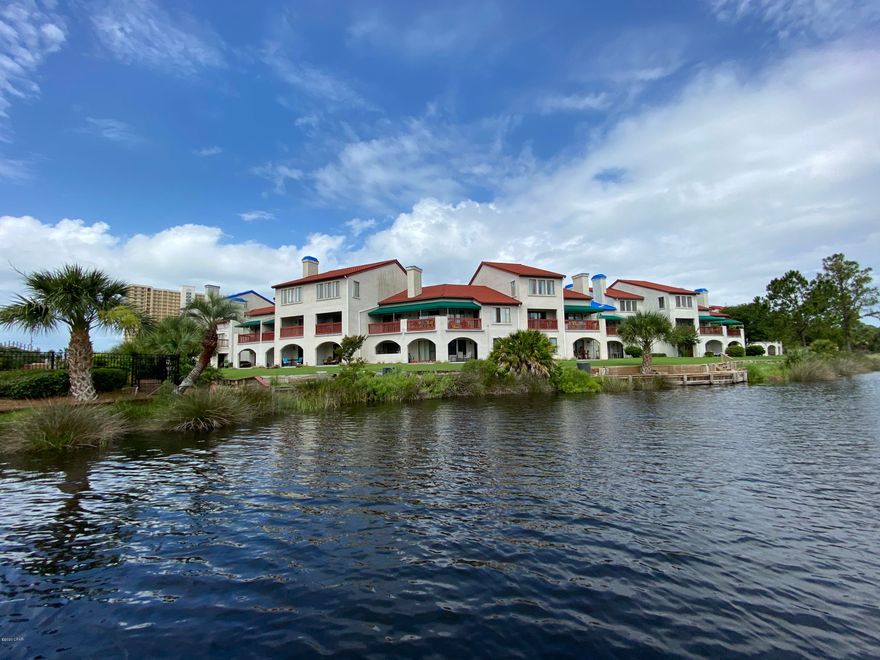Waterfront condo in the gated Villas of St. Thomas overlooking Grand Lagoon AND walking distance to the beach, restaurants & entertainment.  The Grand Lagoon leads to the Gulf of Mexico and St Andrews Bay.  This ground floor 1 bedroom 1.5 bathroom unit is spotless and move in ready.  Freshly painted, new waterproof flooring, updated kitchen, immaculately cleaned and many upgrades. St Thomas Square offers boat dock, pool, sauna, boat storage, tennis courts, shops & restaurants on site and walking distance to the beach. Dock your boat in the water during your stay and get to the beach by boat! Park your car, and never use it while you're on vacation here. Call to see today!