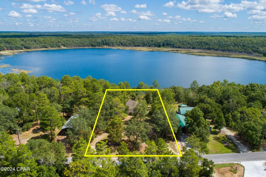 Just reduced this lovely LAKE HOUSE! This  lakefront cabin is on Lake Suzanne inside the Leisure Lakes Community. This well maintained cabin has a sweet southern charm offering a large covered front porch with rocking chairs and a front porch swing! Upon entering the home is a large breezeway/hallway guiding you to 2 large bedrooms and full bath on one side of the home and an open living area on the other side of the home which was common for the era in which the home was built. The flex room at the end of the breezeway is perfect for a dining room, sitting room, etc. The view from this room is spectacular overlooking the lake. The interior of the home features high ceilings with wood walls, ceilings and floors. The exterior of the home offers a laundry room just outside of the flex room, a large lake lot with over acre of land  to run and play as well as an oversized parking area.  The amenities in the Leisure Lakes Community include fishing, a community picnic pavilion with pool on the main lake, tennis courts, basketball court and a playground. You must see this home! It's perfect for full time living in a quiet country setting or a simple weekend getaway for your family only 45 min to the beaches! Roof age is approx. 9 years old, new hot water heater and the home has been appraised at $250,000.00! The home has been under contract before but fell through because the buyer could not sell his home! Neighborhood is gated, you'll need to schedule a showing. All room sizes are approximate, please verify if important.