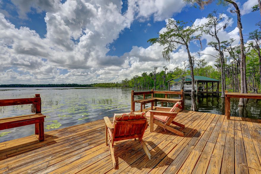 'CURRENTLY UNDER CONTRACT, SELLER ACCEPTING BACKUP OFFERS' 

Warm and cozy log cabin style home made from cedar wood is located on Gap Lake; one of the most gorgeous lakes in Florida, and this home has its own dock. Concrete driveway enhances the beautiful landscaping; and picket fence. Glorious sunsets can be seen from large glass lakefront  living, kitchen and dining area.  There are two bedrooms downstairs & a charming loft seating area overlooking the lake and another master suite upstairs. Flooring is hardwoods and new carpet.  One bathroom on each level .This home can be a great  vacation home/rental, or full time residence. Large deck across the back of home with view of lake. Fish from the dock or just relax and enjoy the view. Sunny Hills is a great place to walk, relax, and escape from the hustle and bustle.
Please verify room, lot sizes, and all information for accuracy.   Please do not
approach without appointment.