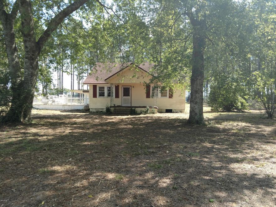 This 2 bedroom/1 bath, vinyl sided home sits on approximately 2 acres. The interior features original hardwood floors, a fireplace with gas logs in the living room, a spacious kitchen with pine cabinets & a family room that spans the back of the house. A two car carport with an attached 12x24 workshop has a covered walkway leading to the rear entrance of the home.  There is also an additional 18x20 metal carport. There are two outbuildings on the property. BEING SOLD AS IS.