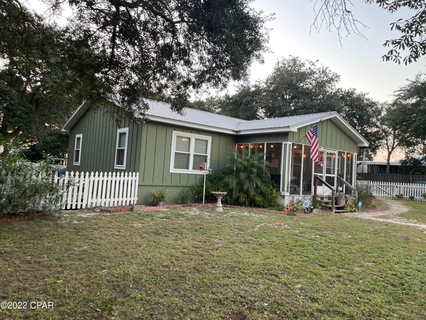 This quaint Florida cottage is nestled among beautiful trees and exquisite landscape and has ample parking and space out back to put in a pool and already has an outside shower, 2 raised flower/garden beds, 80ft deep well for irrigation. Hurricane impact windows, safe room in master closet! The interior is open floor plan, huge kitchen with hickory wood cabinets with reversible doors. Real wood floors and porcelain tile throughout. Property is fenced with texas hurricane wind fence. Two storage buildings! So many great qualities! Call your favorite realtor and see for yourself!