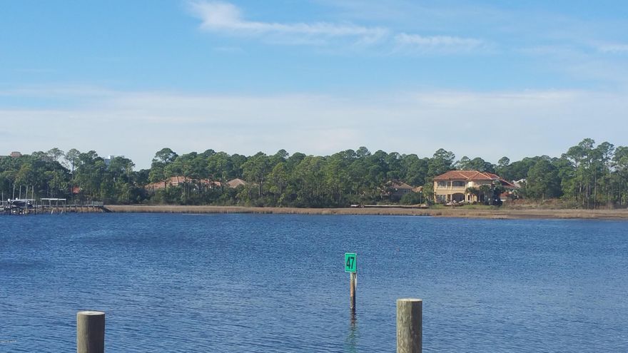Premiere gated Waterfront development with community dock, tennis courts and playground. World's most beautiful beaches, two full-service marinas and world-class dining all within walking distance. Lot has been completely cleared and filled, compacted, and tested. Lot was raise to 6 1/2 feet to provide optimal water views of Grand Lagoon and St. Andrew Bay. Brand new sea wall and retaining wall. You will not find a better waterfront lot in the Panhandle with the value added improvements for this price. It is ready for you to build your dream home!