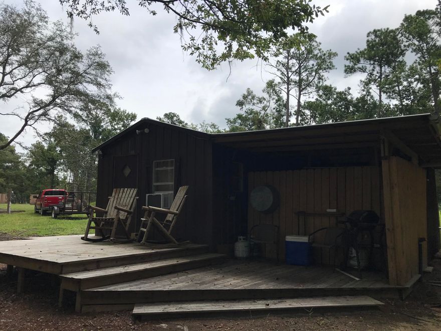 SECLUDED WATERFRONT HIDEAWAY/FISHERMAN'S PARADISE - Already set up 1 BR/1Bath Cabin on 1.325 acres MOL located directly on lake with unattached treehouse.  Land is zoned 100% Conservation so no well, septic, or other building can be built on this property. Use it as a weekend getaway same as the sellers have for years.  Fish with license from your property or climb the steps to the treehouse & sit & watch native wildlife.  Some furniture, refrigerator, floor  heater, window A/C & 14 ft. Jon Boat will convey with sale.   Lemon, satsuma, & pear trees.  Extra RV power pole as a bonus.  80 ft. wood decking walkway from cabin meets a 9 ft. x 24 ft.  dock at water's edge.  Power plug-in on the dock so you can plug in a radio or other electronics.    WHAT BETTER WAY TO BEGIN OR END YOUR DAY!