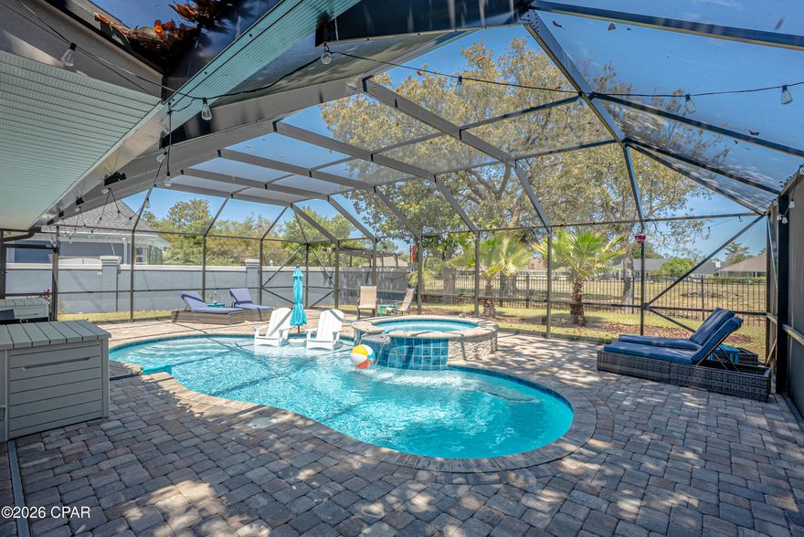 Absolutely stunning brick home featuring a newer Screen-Enclosed HEATED POOL with attached spa, offering a true year-round resort-style experience. This move-in ready property showcases extensive updates completed over the past few years and welcomes you with a grand foyer that immediately highlights the home's spacious layout. Just off the entry, the living room features a beautiful decorative double-sided wood-burning fireplace, creating a warm and inviting atmosphere. The kitchen serves as a central focal point, designed for both everyday living and entertaining, with abundant cabinetry, built-ins, a large island, stainless steel appliances, granite countertops, and a breakfast bar. The formal dining room is conveniently located nearby, along with a bedroom that offers direct access to the pool area. The primary suite also provides private access to the outdoor space and includes a spacious walk-in closet with built-ins and a recently renovated bathroom. Just off the primary bedroom is a private outdoor sitting area, ideal for enjoying your morning coffee. Additional bedrooms are thoughtfully positioned throughout the home, including another bedroom with direct pool access and a fourth bedroom located on the opposite side near a full bath, offering flexibility for guests or family. The laundry room is well-equipped with a washer and dryer, a full-size refrigerator, ample storage, and a utility sink for added convenience.
The outdoor living space is truly the highlight of the property, featuring an in-ground heated pool with attached spa installed in 2022/2023. The brick-paved patio and lounging areas create a resort-like setting, complete with a tanning ledge and plenty of space to relax or entertain while enjoying the Florida sunshine. The backyard is fully fenced for privacy and enhanced by mature landscaping. Inside, the home offers low-maintenance finishes with real wood Australian Cypress flooring throughout and tile in the bathrooms and laundry, with no carpet. Numerous recent improvements include new windows and doors, updated laundry room, new HVAC system, renovated primary bathroom, updated stainless steel kitchen appliances, blackout shades, and more, with a full improvement list available. Additional features include crown molding throughout, updated lighting and ceiling fans, a pool ozone system, attic storage, an extended garage for extra storage, a brick-paved driveway, and a sprinkler system on a separate meter. Located within the gated community of Bay Point, residents enjoy 24-hour security and access to an exceptional lifestyle with a Nicklaus-designed golf course, a remodeled marina, dining and entertainment options, tennis facilities, scenic walking paths, and community events throughout the year.  Bay Point offers convenient boating access with a short ride to Shell Island and is just minutes from many of the area's top restaurants and attractions. If this home meets your criteria, contact your preferred real estate professional to schedule a private showing. All information, including age, square footage, room dimensions, taxes, and school zoning, is deemed reliable but not guaranteed and should be independently verified by the buyer.