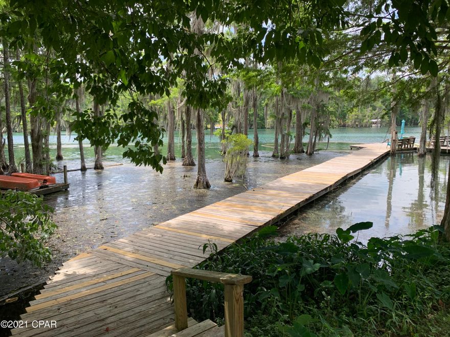 This 2 bedroom condo is being sold mostly furnished AND comes with its own boatslip! Situated on famous Merritt's Mill Pond, a unique 202-ac spring-fed pond with crystal clear waters. Merritt's Mill Pond is sought after by divers, fishermen or anyone looking to spend time on the water. Enjoy stress free living with lawncare provided by HOA for a low rate of $50/mo. Community offers a dock &dedicated swim area or enjoy the serenity from your own covered backporch! Two spacious bedrooms upstairs w/ shared bathroom.  Don't miss out on this opportunity to own a slice of paradise! Buyers please verify measurements.