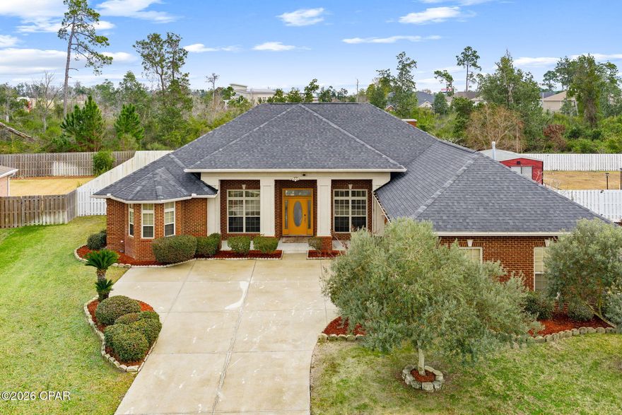 Custom-built all-brick home showcasing timeless architectural and designer details, located in the highly desirable Woodrun community. This well-maintained neighborhood offers sidewalks, curbs, and convenient access to the Highway 77 corridor, shopping, dining, and entertainment.

From the moment you arrive, you'll notice the artistic etched glass front door and transoms, designed and signed by artist Patrick Reynolds, creating a striking and memorable entrance. Inside, the split floor plan offers both privacy and functionality, with an open-concept layout ideal for everyday living and entertaining.

The kitchen is thoughtfully designed with custom mahogany cabinetry, granite countertops, gas cooktop with designer hood, under-cabinet lighting, ample storage, and a breakfast bar that opens to the main living areas. Ten-foot ceilings throughout enhance the home's spacious feel. Floor outlets in both the formal living room and great room allow for flexible furniture placement and interior design options.

The primary suite features a tray ceiling and a spa-inspired ensuite with a soaking tub, separate shower, and dual walk-in closets. A dedicated office provides flexible space for work, guests, or hobbies. A well-appointed half bath is conveniently located near the formal living area for guests.

Recent improvements include a tankless water heater (2024), furnace (2024), Dishwasher (2024), and a roof replaced in 2019, offering added peace of mind. The washer and dryer will convey with the home for added convenience.

The great room is highlighted by an electric fireplace, creating a warm and inviting focal point. Multiple rooms open to the screened-in rear patio, offering a seamless indoor-outdoor living experience. The private, fully fenced backyard includes a brick grilling area with pergola: ideal for relaxing or entertaining in Florida's coastal climate.

This thoughtfully designed home combines quality craftsmanship, functional layout, and classic style in a sought-after location.