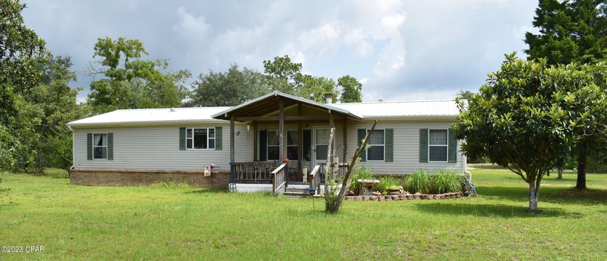 1204 Crooked Ln is a 4.25 acre piece of paradise.  Fruit trees, beautiful lawn and parking for toys, RV's, and much more are all secluded from the road by a wall of Azaleas and trees.  Metal roof on the house will insulate and endure winds.  Real brick wall skirting the bottom of the double wide keeps under the house dry, and protected.   Outdoor living is easy with a 26 foot by 11 foot plus screened porch that looks over park like back yard.  First RV parking spot is wired, plumbed, covered.  Second RV parking spot is double tall and 56x24 built with steel girders.  Inside the house enjoy a living space with fireplace, crown molding in your 26x22 foot living room.  From the living room, walk through the dinin area then into the kitchen that has a pantry, island, breakfast counter and lots of cabinets.  Turn left from the kitchen down the hall to the full bath, 2 bedrooms and a laundry room with a door that leads to the screen porch and carport.  At the other end of the house (split bedroom) you will find the master suite with a 13 foot long walk in closet, vaulted ceiling, and 13 by 15 master bathroom.  There is a double vanity and a make up station in there as well.  Now, about that 56x20 workshop with 240/120V wiring, woodburning stove for heat, metal roof, metal siding, concrete floor, 3 bay doors, and extra carport space to boot. If you have toys to cover and tools to get work done, 1204 Crooked Lane will suit you perfectly.