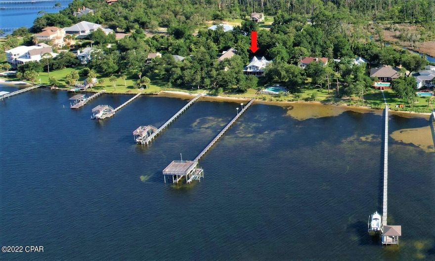CURRENTLY UNDER CONTRACT, SELLER WILL CONSIDER BACKUP OFFERS- One-of-a-Kind Bay front home in Bear Point in Panama City Beach!  The square-footage is combined with the main home at 2,951 sqft and the guest house with 448 sqft.  This custom built, 2-story home offers gorgeous views of historic St. Andrews Bay! With a shared boat dock which has a dedicared lift, you are literally 8 minutes from the pass and Gulf of Mexico.  This 4BR/3BA home was built in 1991 with 2x6 construction and has been upgraded recently!  Some of the NEW includes a roof in 2019, hickory floors and new carpet installed, the Kitchen cabinets and built-in entertainment center with fireplace are Mahogany with special pull-out drawers and shelves, new stainless-steel appliances including TWO ovens and a flat cook top ran new doors on the garage and front entrance. The sellers say they will miss the huge screened veranda on the back of the home where they enjoyed watching the deer walk thru and the dolphins frolicking in the bayalmost daily!  The loft area upstairs also offers a terrific view from inside as well as the balcony!  Additional features include a split-bedroom floor plan with the master suite on the 1st floor, a formal dining room and a separate breakfast nook, and a storage/safe room under the stairs.  Let's not forget the detached 1BR/1BA cottage with luxury plank vinyl flooring, a full kitchen, and living area great for family or friends.  The boat dock has an observation deck over the slips where you can enjoy watching the sunrise and sunsets! And while the home itself is impressive, the neighborhood is the icing on the cake! Located on the end of historic Bear Point at Magnolia Beach, you've got a private drive with no fences, lush park-like atmosphere You will love the laid-back atmosphere and calling this home. All info is approx. and must be verified by Buyers if important.