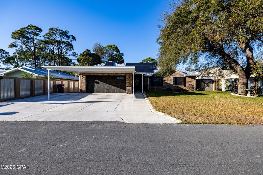 Just off Thomas Drive and directly across from Publix, this beautifully maintained 3-bedroom, 2-bath brick home offers the perfect balance of beach convenience, privacy, and functionality.

Originally built in 1993 and thoughtfully updated since 2017, the home blends solid construction with modern upgrades and distinctive interior craftsmanship. 

Inside you'll find luxury vinyl plank flooring, solid wood interior doors, tongue-and-groove paneling, and craftsman-style trim that create a warm, cohesive feel throughout the home.

The kitchen features Samsung stainless appliances, farmhouse-style touches, and inviting lighting, opening naturally into the dining and living areas where a custom fireplace and rustic wood accents create a comfortable gathering space. 

Each room reflects pride of ownership and intentional design. With 1,756 heated and cooled square feet (2,412 total under roof), the home also offers impressive efficiency thanks to solar panels that have reduced the current owner's electric bill to approximately $30 per month, along with newer windows that enhance comfort year-round.

Outside, the property is built for both practicality and entertaining. An expansive insulated metal panel covered driveway provides space for up to six vehicles in addition to the two-car garage, making it ideal for guests, boats, or multiple vehicles.

The large covered rear porch and outdoor dining area, also built with insulated metal panel roofing, create a shaded and comfortable outdoor living space. Custom sun shades add additional cooling, making it perfect for relaxing or entertaining after a day at the beach.

The backyard has been designed for low-maintenance enjoyment, featuring paved walkways, decorative pebble rock borders, and a stylish custom fence with wood framing and corrugated metal panels. A large side gate provides access for equipment or a tractor and leads to a dedicated workshop/storage area with pegboard walls, plus an additional covered lean-to for tools and lawn equipment.

And for buyers who fall in love with the style, much of the home's furniture and décor is negotiable, offering the opportunity to purchase the home nearly turnkey.

Located just minutes from the beach, dining, and shopping, this solid brick home combines location, character, energy efficiency, and exceptional parking