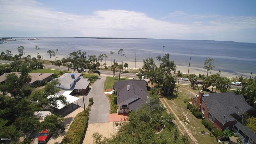 Delightful Southern charm fills this Beach Dr. home on St Andrew Bay  that offers the comfort and history defining Cove living.  Nearly an acre of land with open views of St Andrew Bay. The craftsmanship and attention to detail of this classic home is of the highest quality. Solid hardwood oak floors throughout along with all block construction. Cozy kitchen with granite counter tops. Open sunroom, and family room with beautiful water views, two comforting fireplaces, and ample space provide endless possibilities for your family to enjoy. The main home overlooks St Andrew Bay while the carriage hse with upstairs 2 bedroom apt can be accessed from 7th Ct. at the back of property & previously rented at $1100/mth.