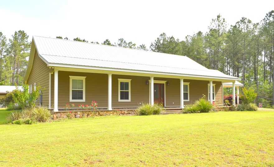 Tucked amongst the matured pines, this home captures the essence of true country-style! Enter through the front door and you are immediately greeted with an oversized foyer, engineered hardwood floors that lead into the massive open living/dining/kitchen area with granite countertops, hammered copper sink overlooking the back yard, stainless steel appliances, custom cabinets, island, breakfast bar and large walk-in pantry. The split floor plan provides privacy for the Master Suite that boasts custom tiled shower, his/her sinks with granite countertops and an oversized walk-in closet adjoining the laundry room. Outside features include front and back porches that extend the entire length of the house, small pond, attached carport and a 38x36 shop with 2 roll up doors. Tucked amongst the matured pines, this home captures the essence of true country-style! Enter through the front door and you are immediately greeted with an oversized foyer, engineered hardwood floors that lead into the massive open living/dining/kitchen area with granite countertops, hammered copper sink overlooking the back yard, stainless steel appliances, custom cabinets, island, breakfast bar and large walk-in pantry. The split floor plan provides privacy for the Master Suite that boasts custom tiled shower, his/her sinks with granite countertops and an oversized walk-in closet adjoining the laundry room. Outside features include front and back porches that extend the entire length of the house, small pond, attached carport and a 38x36 shop with 2 roll up doors. House is situated on over 11 acres conveniently located off Pioneer Road minutes from Hwy 79 and Hwy 77.