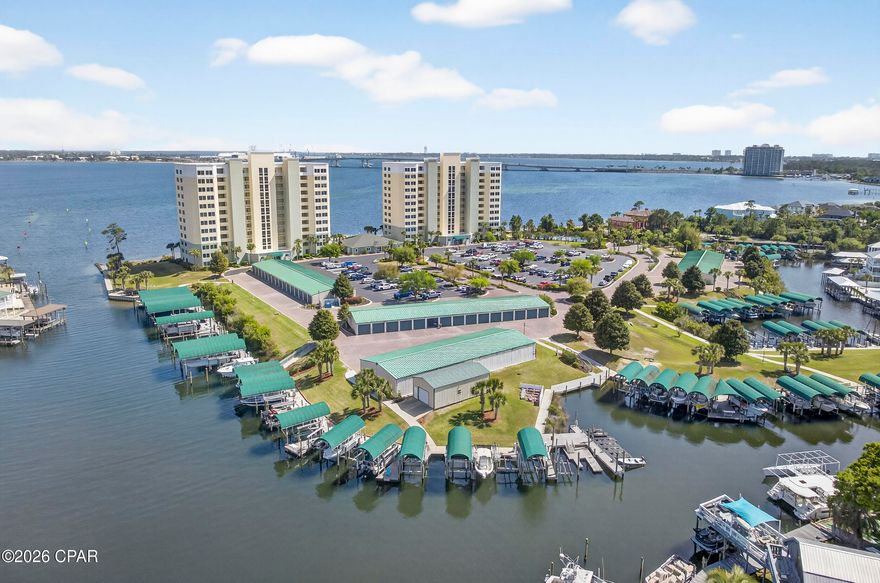 Waterfront living with beautiful views- this community has it all: boat slips and garages (for sale or rent); jet ski slips; over 400' ft fishing pier; gilling stations; tennis or pickleball court, fire pit; and walkway stairs into the gulf for your paddle board or kayak; plus you are just minutes from Shell Island and the pass out to the Gulf! This gorgeous home has been beautifully renovated with a spacious utility room for the washer/dryer and plenty of shelving, There is also a separate pantry for extra food storage. The kitchen features plenty of cabinets with quartz countertops; stainless appliances; dining area for entertaining; and separate sitting area. The large open great room boasts an inviting balcony with a stunning view of the bay. The balcony sliders are hurricane rated and were replaced last year. The sunrises are magnificent! The huge primary bedroom features custom paint color, trey ceiling and another amazing view of the bay and primary bath with jacuzzi tub, separate shower and double vanities. The secondary bedroom is quite spacious and has a full bathroom just steps away. This amazing home also features LVP flooring throughout and lovely custom paint. Another amazing feature of this lovely condo is that it comes completely furnished! The community completed the Structural Integrity study and invested millions in improvements with no extra cost to the residents - including the recent renovation of the pool deck with exquisite Travertine Tile. The amenities also include a community room for gatherings; a gym; and a tranquil library for reading or working in a peaceful area at no extra cost to residents.  There are no short term rentals which help keep this community a more relaxed lifestyle with an atmosphere of unity and long term friendships. The HOA includes water, garbage, pest control, high speed internet which includes over 100 free TV channels- including HBO, Showtime, and Starz. The HOA also includes a gated entrance, and cameras for security. This community is truly an exceptional place to live!