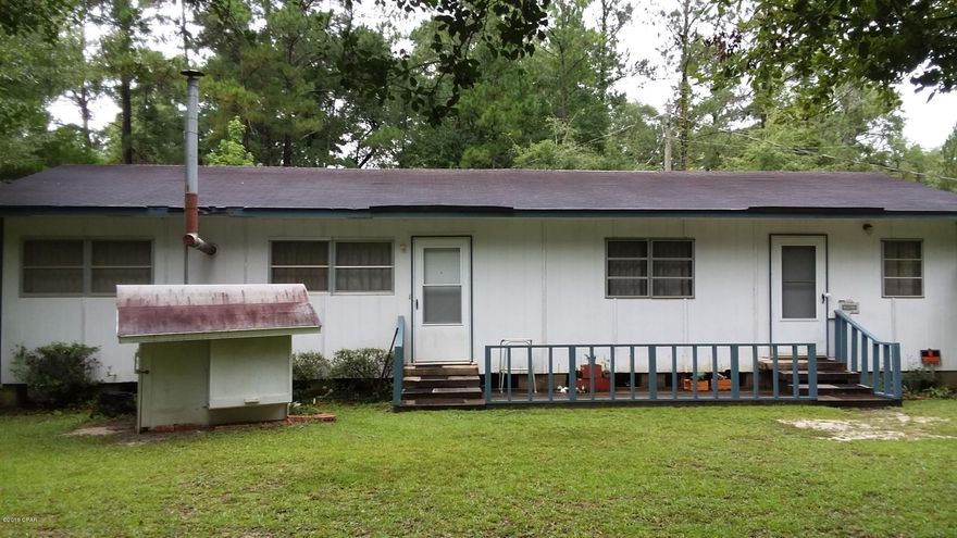 Well preserved older mobile home on 3.2 pretty acres with detached workshop. 2 BR, 1 BA single-wide with large wood frame addition across the front for 1144 sq feet with central heat/air. All plywood floors with same vinyl flooring throughout the home. Front room has built in wood shelves & was used as a library. Spacious living/dining area with kitchen featuring wood cabinets. Large insulated room has laundry area, cast iron wood heater, wood shelving & outside door but still needs wall covering (such as paneling or drywall). Detached workshop with concrete floor & electricity. Some of land is in a flood zone, however, the home has never flooded. Another single-wide directly behind the home was used as a mother-in-law apartment but is of no value. Walking distance to Choctawhatchee River!