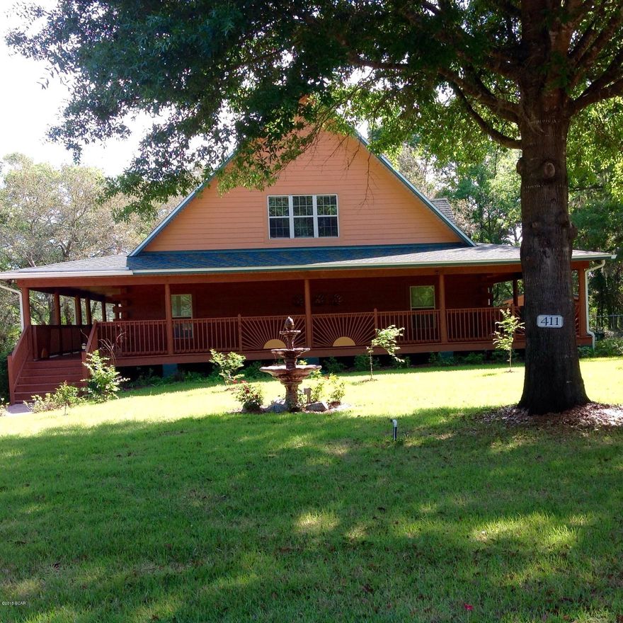 Unique Log Cabin secluded and fully insulated (icynene) sitting on Deer Point Lake with almost 3 acres at the end of a quiet-cul-de-sac. Home has a wrap-around covered porch on all four sides with three exterior doors. There will be shade somewhere all the time. Beautifully landscaped grounds with an impressive Brick Driveway lined with Knockout Roses. Several Fruit tree are on the property. Main part of the yard has a chain link fence with an electric gate. While you are enjoying the Sunrise or Sunset you and fish off your dock and watch the wildlife roaming around. The Open Floor plan features a large Updated Kitchen with Breakfast Bar, Lots of Cabinets and a Dining Area. The Living area has 30ft ceiling. A stairway leads up to the Loft area which is your 3 bedroom, office, game  room, or whatever you need it to be. It looks down over the Living Area with hardwood floors. Master and Second Bedrooms are on the first floor. Best tasting well water with the update purification system. Metal roof is about 2 years old. Hugh Garage (40 x 30) will fit 4 cars and still plenty of room for tools and storage or a MAN cave. If you are looking for peace and quiet yet only 5 minutes to Lynn Haven, this is it. This could be your home or a quite get-away. Furniture can be included with this home for the right price. If measures are important, please measure.