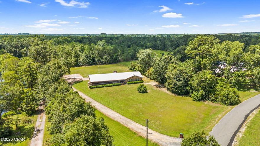 Magnificent Country Home sitting on 5.4 acres just out of town. Home boasts  an open floor plan featuring a living room with a stone faced fire place with gas logs, large dining room flowing from the updated kitchen with new granite counter tops that are gorgeous,  Split floor plan with 3 large bedrooms, 2 baths, updated electrical, new roof in 2019, propane gas powered whole house Generac.  Extra large 970 sq ft covered front porch large enough for entertaining and relaxation with plenty of shade. Home has water view from the back of house, approx 4 wooded acres. 2 minutes north of Graceville Fl, 15 minutes to I-10 corridor, and 25 min to Dothan Al. Make your Appt. today ! BRING ALL OFFERS, MOTIVATED SELLER.
