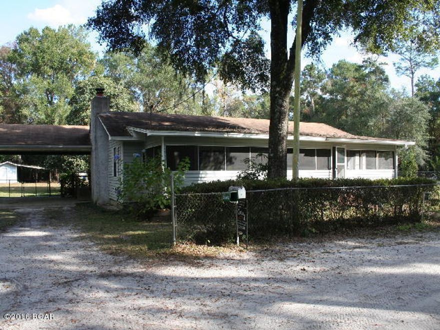 Large home in recreational neighborhood of Smith Creek at Ochlocknee River. Perfect spot for weekend getaways for fishing and hunting near a popular National Forest, also would make a fine permanent home. Home has many nice features; a large living room with fireplace insert, very large kitchen with nice cabinets, an extra large room that doubles as an office with the laundry area, 3 bedrooms, 2 baths, a sitting or hobby room next to the master bedroom, a den or sunroom off the kitchen area. Then across the entire front is an enclosed screened porch. The lot is completely chain link fenced! There is an attached 2 car carport. The front yard has a small water feature. The back yard has a shed for the well with a covered lean to/workshop and a small barn with double lean-tos for housing your boats, a pen that could be used as a chicken pen or dog pen. And all of this is only one street away from the river where there is a boat ramp for launching your boat.  Room sizes are estimated.