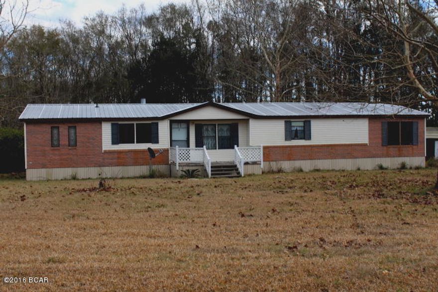 PRICE REDUCED!!   Lovely renovated and updated doublewide on 1.12 acres of land on paved road only a few minutes to town!  There is a large den with fireplace, a formal living room, cute dining area and large kitchen.  It has a split bedroom design and the master bedroom is large and roomy.  The kitchen has all appliances and there is a nice covered back porch.  A metal yard building with covered area just right to park your boat or yard equipment under is included.