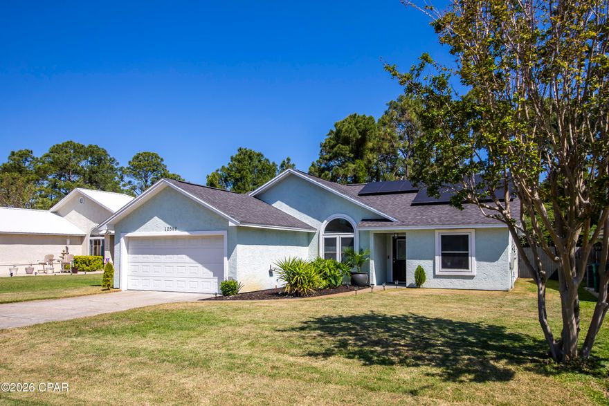 This beautifully maintained and thoughtfully updated 3-bedroom, 2-bath beach home is ideally situated on a quiet cul-de-sac in the heart of the central beach area. Designed with a light, airy coastal aesthetic, the interior features fresh paint throughout and stylish finishes that create a relaxed, move-in-ready retreat. The spacious 21x15 living room is enhanced by vaulted ceilings, offering an open and inviting atmosphere. The kitchen is both functional and appealing, featuring stainless steel appliances, cream-colored solid surface countertops, and crisp white cabinetry. Durable vinyl wood plank flooring runs throughout most of the home, combining style with easy maintenance. A desirable split-bedroom floor plan provides privacy, with a well-appointed primary suite offering dual closets and an updated en-suite bath complete with dual vanities, marble countertops, upgraded fixtures, and designer touches including coastal-inspired accents. Two additional bedrooms share a full bath with an upgraded vanity, lighting and plumbing fixtures. Step outside to enjoy a fully fenced backyard with well-maintained landscaping, supported by a sprinkler system on a newly installed shallow well pump. The outdoor space also includes a storage building and a shaded patio-perfect for relaxing or entertaining. Energy efficiency is a standout feature, with paid off solar panels keeping the current owner's electric bill at approximately $40 per month. Located just minutes from the beach, this home offers easy access to local favorites including Pier Park, Pirates Voyage Dinner & Show, and Topgolf Panama City Beach, along with shopping, dining and other entertainment options. Whether you're looking for a primary residence, vacation getaway, or investment opportunity, this home delivers the perfect blend of comfort, style, and location.