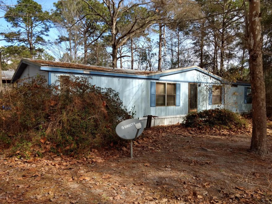 Great Deal! Older mobile home on 5 acres. Roof has been replaced, has a good metal roof now. Previous roof had some damage from fallen limbs. Some of the ceilings have water damage, house needs work. Has good deep well and septic in place. Has a large horse barn with nine stalls. Also has a large pole barn in good shape. Very nice 5 acres all high and dry. Most of property has been cleared and has some fencing in place.