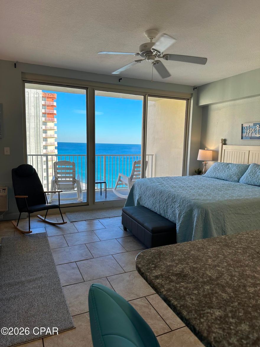 Gulf-Front studio at Shores of Panama with a deeded parking spot. Enjoy breathtaking views of the Gulf from the 18th floor with floor to ceiling windows that open to the balcony with 2 rocking chairs and table. The studio condo  has been newly painted from ceiling to walls, trim and cabinets throughout in Nov 2025 including new room darkening curtains. The unit features tile throughout, including a stackable washer and dryer in the hall closet, ceiling fan and a new AC unit in March 2025. Kitchen includes an electric stove, dishwasher, fridge, coffee pot and new microwave Nov 2025. All cooking and serving wear included (All serving items new Nov 2025). The bathroom includes a tub/shower combination with a new light and mirror in Nov 2025. In the main living area all furnishings are included in blue and grey tones. The main living area has 4 new lamps with charging ports, 2 new end tables, 2 new 3 drawer nightstands, 2 new benches (entry and end of bed/with storage), and a new couch that converts into a futon bed, new rocking chair. There are new 2 bar stools with a 42inch new smart TV on a swivel mounting bracket above the bar kitchenette. The king size bed has a new top firm mattress and new bedspread and shams. All new in Nov 2025. The deeded parking spot is located on the 9th floor. This condo is used as a short -term rental. The amenities that the Shores of Panama include are a fitness center, and heated indoor pool and hot tub.The property also includes an outdoor pool, hot tub, short order poolside restaurant and separate tiki bar all within a secure area. There is 24 hour security throughout the property. Wristbands are used to enter the property through vehicles or walking in from the public beach. This unit has everything needed for permanent living, long or short term rental property. More pictures of the unit available on request.