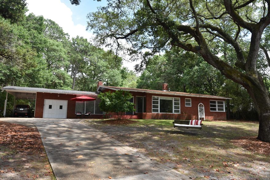 Bayside Subdivision ... much sought after neighborhood ... situated on beautiful quiet Lake Caroline ... short walk to St. Andrew's Bay.  Walking distance to ''downtown'' Panama City and west to St. Andrew's area.  Beautiful bay front parks nearby ... great area for walking and bike riding.  4/2.5 all brick home on large lot with in ground pool.  Space galore for backyard play!  Concrete drive goes from E Caroline Blvd down side of property and exits through 2 gates onto 10th Ct ... room for RV or boat to drive through.  Dramatic foyer reflects the calm spirit of this home ... owner has maintained the warm character throughout!  Original closets throughout and lots of them.  Living Room provides a setting for relaxation and is large enough for entertaining. Panoramic picture windowed view of Lake Caroline.  Spacious but intimate dining area ... only a step to the well designed modern kitchen ... granite counter tops ... tile floors.  The perfect den - quality fireplace is the focal point of the den ... from floor to beamed ceilings.  Entire room has a warm, friendly atmosphere.  Master BR with deep shower.  3 additional BRs with 1 more full bath inside ... 1/2 bath outside by pool. 1 of the BRs is being used as a large walk in closet.  You have view of backyard with pool and/or front yard view of Lake Caroline from every room. Outdoor patio area is just off the kitchen ... makes entertaining comfortable and easy!  All measurements should be verified for accuracy.  Don't hesitate!  Call today for private showing.