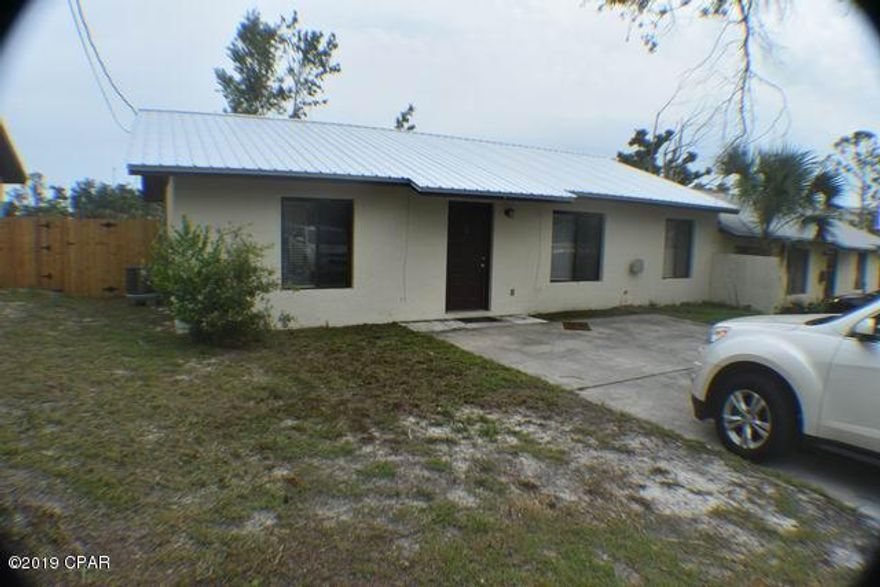 Highly sought after COVE area. Half of a duplex with a spacious open floor plan. Great room has vaulted ceiling with decorative molding and a tiered wall space with recessed lighting. Freshly painted inside and move-in ready. New easy care vinyl plank flooring. Ceiling fans, Laundry room leads out to deck and fully fenced back yard. New metal roof, well equipped kitchen with almost new appliances. Baths are tiled. Excellent location and convenient to downtown and all of Panama City. Not far from Tyndall, Callaway, Lynn Haven or the Navy Base.  In Flood Zone X,