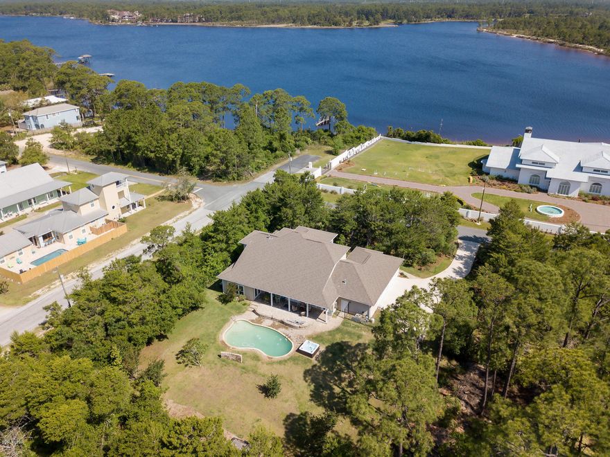 This gorgeous 4BR/4.5BA home is almost 3,500 square feet and features large rooms, an open concept, serious upgrades, a hot tub and beautiful pool...just for starters. Behind the gated entrance, there is plenty of room for all of your vehicles and toys and a sprawling, private rear yard. You can prepare a wonderful meal in the fabulous kitchen while your guests mingle in the large living area or out on the large covered patio. Downstairs, there is a master suite and additional bedroom while the main master sprawls across most of the upstairs with gorgeous views of the water. Located on the desirable west end of Panama City Beach, you are just minutes from Pier Park to the east or Inlet Beach and 30A to the west. NEW dishwasher, NEW refrigerator, NEW 5 ton HVAC, NEW Rinnai tankless water heater and whole house water purification system all included. Seller is in the process of splitting this lot from the adjacent acreage.