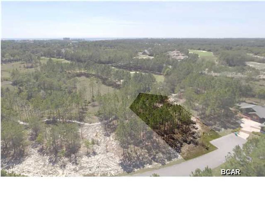 This executive lot is strategically located on the eighth hole of the prestigious Greg Norman's Shark's Tooth golf course, with its 25,000 square-foot clubhouse. Wild Heron's pristine landscaped 734 acres provide a peaceful respite from the nearby commercial and vacation mecca of Panama City beach, and is just minutes away from Pier Park, Rosemary Beach, and the airport. The abundance of amenities include the architecturally-impressive Boathouse and dock with kayaks provided, heated pool and spa, rare coastal dune lakes for fishing and paddling, Har-Tru tennis courts, fitness center, nature trails, boardwalk around Lake Powell, barbecue pits and playgrounds. The development of Wild Heron, a Coastal Craftsman community, serves to substantiate the value of this property.