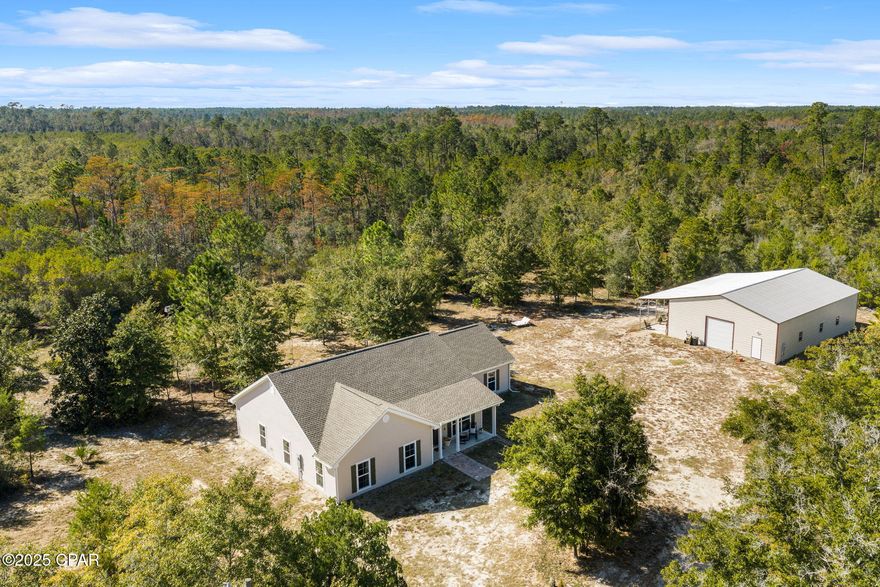 Note: For safety and access, all showings must be accompanied by a licensed real estate agent with an approved appointment. The home sits approximately 0.4 miles off E. Hwy 388 with one private entry in and out.

Come explore your slice of paradise on this 33.5-acre property featuring a 3 bedroom, 2 bathroom home built in 2022. Approximately 3 acres are cleared, offering a perfect blend of open space and natural privacy.

One of the highlights of this property is the 2,400 sq. ft. workshop, ideal for tools, equipment, hobbies, or storage. The workshop has power (not heated or cooled) and includes an additional 600 sq. ft. lean-to with a 50-amp connection, perfect for parking your RV.

The home is not located in a flood zone. Built by Americas Home Place, the residence offers 1,898 sq. ft. of living space. Inside you'll find an open floor plan connecting the kitchen, dining, and living areas. The kitchen features a center island with bar seating for more casual dining, granite countertops, recessed lighting, double sink, Whirlpool appliances, soft-close drawers, and a walk-in pantry.

The spacious primary bedroom easily accommodates a king-sized bed. The primary bathroom includes two closets, double vanities, a separate shower, and a soaking tub with a large window that provides a view of the stars.

Enjoy your mornings or sunsets through the double French doors on the screened-in back porch or front porch, where you can watch deer and wild turkeys roam. 

The property features secluded walking trails surrounded by oak, pines, magnolia, and two cypress ponds.

This unique Bay County property offers the peace and quiet of country living with convenient access to town. Located approximately 25 miles from the world's most beautiful beaches, 20 miles from  Northwest Florida Beaches International Airport, and 10 miles from Lynn Haven/Panama City, Florida.

Deed restrictions apply. No subdividing. Starlink is available for internet. Buyer to verify all measurements and information that is important.