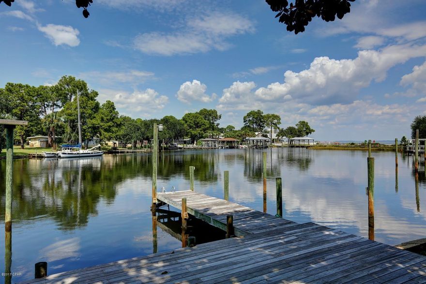 ATTENTION BIG BOATERS! This Panama City Beach waterfront home has 110 ft on DEEP WATER! Perfect for your BIG BOAT OR SAILBOAT! Dock your boat behind your home and enjoy incredible open water views from this spacious waterfront sanctuary. This well cared for home has 4 bedrooms, 5 baths, office, living room, dining room, great storage and an awesome family room. All of this sq ft and all ONE STORY living.  Lots of light and views from almost every room. Kitchen with huge walk in pantry, 2 master suites, 3 fireplaces, lots of built ins, 2 car garage with oversized drive for extra parking are just a few of the features. You are going to love the family room on the back of the home.  This home has been a lifetime of hosting and entertaining. Call today and make this house your HOME!