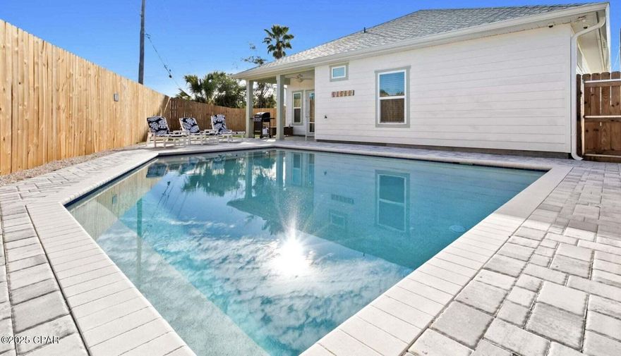 Paradise found at 21400 Marlin Avenue, a perfect beachhouse with a POOL in Panama City Beach, FL! Escape to your dream vacation home located in the heart of Panama City Beach, 1/2 MILE from sugar white sand beaches and pristine waters of the GULF OF MEXICO. NO HOA, Short Term Rentals ALLOWED and just minutes from local restaurants & all the adorable neighboring beach towns of iconic Scenic Route 30a. This turn-key pool home built in 2021, is like-new, offers easy access to the nearest gorgeous beaches located at the desirable West End of Panama City Beach. Welcome to 21400 Marlin Avenue, complete with coastal inspired furnishings, kitchen essentials, decor, and a 4 seater electric ICON golf cart to convey; It is the perfect blend of coastal charm and modern luxury, making it a retreat for relaxation and entertainment. Ideal for a primary residence, second home or vacation rental. As you enter into this beautifully designed coastal beach home, you will be greeted with an open floor plan that maximizes space and natural light. The kitchen is the heart of the home and provides the perfect gathering spot with a spacious 9 foot kitchen island adjacent to the dining space. The kitchen is a culinary delight accented with beautiful subway tile, to convey with all your cooking essentials; stainless steel appliances, and granite countertops offer plenty of space for cooking and entertaining while soft-close shaker cabinets provide ample storage. This truly turn-key vacation home gives all the beach vibes and provides everything you need for a successful vacation rental and beachside getaway. Housed in the spacious 2-car garage, a 2 year old ICON 4 seater electric golf cart to explore the coast, -will convey with the sale; along with stylishly furnished living and dining areas with coastal-inspired decor, this beach house is ready to host many beachside memories. Generously sized, beach-inspired bedrooms provide comfort and privacy for all guests. The spacious primary bedroom has tray ceilings, views of the pool from the bedroom window, and an en suite bathroom with double vanity sinks, granite countertops and stylish floor-to-ceiling shower tile make for a five star experience. One guest bedroom hosts a queen bed and the other guest bedroom has queen sized bunk beds for the comfort of your guests. Sellers have added a number of upgrades to the home to include a Nest thermostat, for energy-efficient climate control. The homeowners have also maximized the corner lot to create an expansive outdoor living space by adding a sparkling 350sqft in-ground saltwater pool surrounded by pavers. The Sellers paid the county to run a gas line from down the street to the home, ensuring a reliable gas supply. The pool is gas heated and comes with an automated programmable system, ensuring year-round enjoyment.
