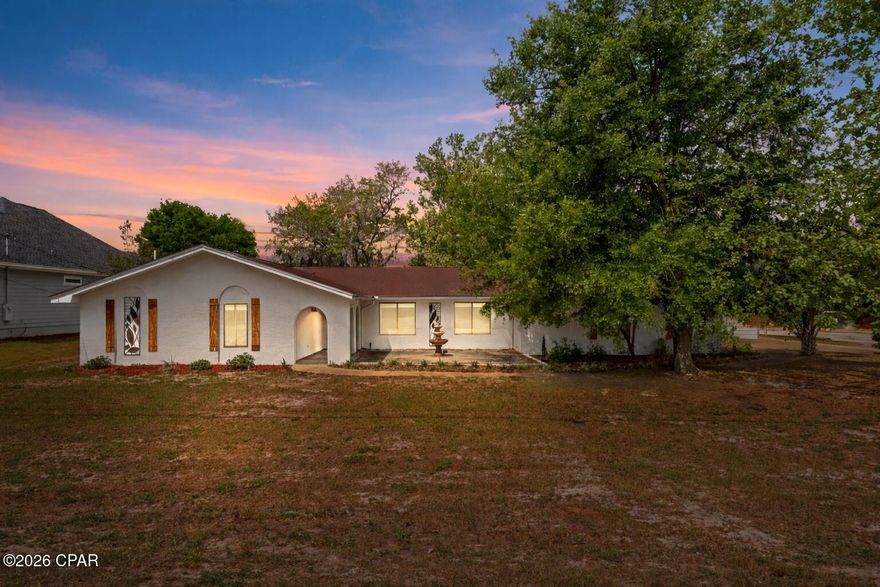 Enjoy living in this spacious single-story home on a desirable King's Ranch corner lot. The flexible layout offers approximately 2,494 sq ft, 3 bedrooms, 3.5 bathrooms, a large office, and an option for a 4th bedroom. 
As you arrive at this beautiful Spanish-style home, you will be greeted by an oversized arched covered walkway, complete with pavers, overlooking a large Spanish-style patio, perfect for morning coffee or afternoon tea, as you take in the Florida air and sunshine. Step inside through the solid wood door to be greeted by ample natural lighting, a spacious layout, and tasteful customizations that really bring out the home's character and style. As you explore this home, you'll find an open-concept floor plan with extra-large rooms throughout, a cozy wood-burning fireplace, and multiple living and dining spaces perfect for entertaining. The kitchen is well-appointed with stainless steel appliances, abundant cabinetry, and a breakfast nook, plus a large wet bar for added luxury. The split-bedroom layout provides privacy, with oversized bedrooms featuring double closets and en-suite bathrooms in the primary and one secondary bedroom. The primary suite also offers a private retreat feel with generous space and comfort. The custom Master Bathroom features floor-to-ceiling tiles, a double sink, and a large walk-in closet. The living area overlooks the spacious backyard, with a large coved patio that not only adds a unique sense of character but also provides a place to enjoy the weather on those lazy rainy afternoons. Completely fenced in with a low-maintenance metal privacy fence, hiding you away from the rest of the world. Enjoy the pergola, fire pit, and the second workshop, tucked away out back. Take a relaxing break in the hot tub or enjoy the breeze under the shade tree. Additionally, this home features an oversized double garage, an indoor workshop, a spacious laundry room, luxury vinyl plank flooring throughout, recessed lighting, and an outdoor shower. 
Experience all this home offers, from its Kings Point location just moments from gulf and bay access, to ample nearby shopping, dining, and entertainment. Reach Panama City Beach's famous white sand beaches with a short drive. Schedule a showing soon, as this property is priced to sell quickly. Call your favorite Realtor today!