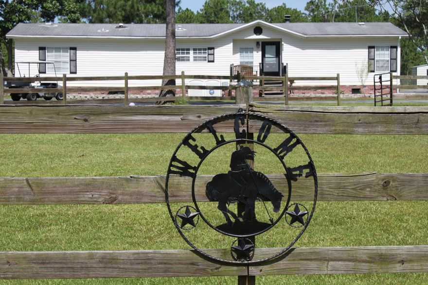 HUGE REDUCTION!!! Have you ever thought about owning a beautiful home in the country, but not too far away from town?  Do you want to own enough property that you can have large animals that roam the pastures?  How about your own tack and feed room with four stalls for horses?  Well then, this is the perfect property for you!  Whether you own horses or not you will love this 3 bedroom 3 bath home with it's very own LARGE Game Room, Den or additional Bedroom/ Office.  Its screened porch and many covered spaces protects you from the sun while giving you additional outside entertainment space.  Lets not forget about its separate two car garage and paved circular driveways with additional paved parking in the rear.  Included in the sale is a nice single wide m/h that is currently rented.