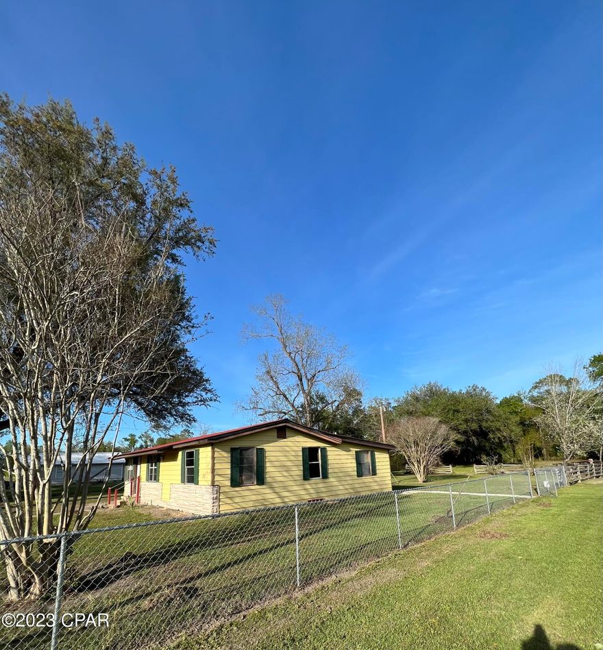 This charming 3 bed 2 bath home sits right in the heart of Grand Ridge. This home is fenced in with new chain link and is accompanied by a large storage shed. The adjacent parcel containing approximately half an acre is included in this sale, totaling 1 acre, more or less. This home has well water and city sewer. Located less than 50 miles from Tallahassee and 80 miles from Panama City Beach, this home is in the perfect location. Come and enjoy country living at it's finest. Call today to schedule an appointment!